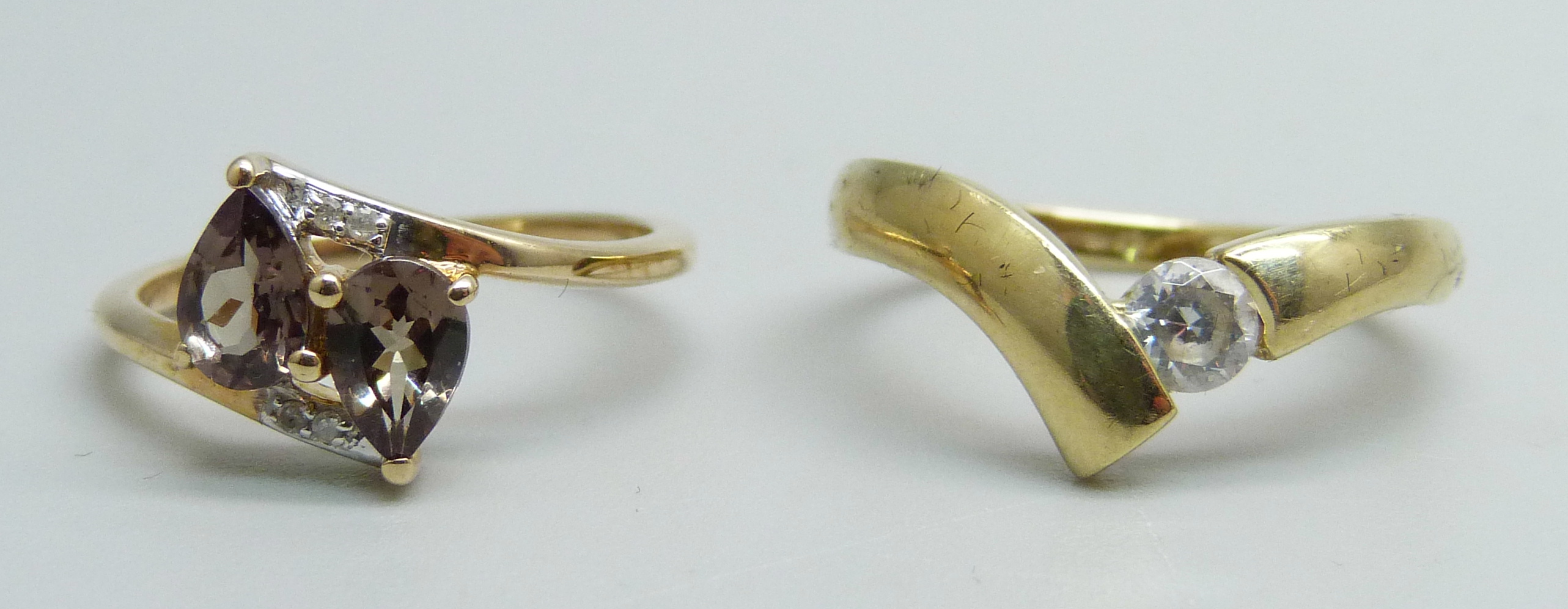 A 14ct gold solitaire ring, 2.1g, M, and a 10k gold crossover ring, 2.1g, L