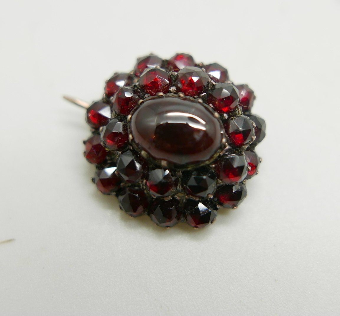 A Bohemian garnet brooch set in a yellow metal mount, tests as gold, 3.3g, 1.9cm