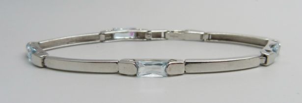 A 9ct white gold and topaz tennis style bracelet, 7.2g