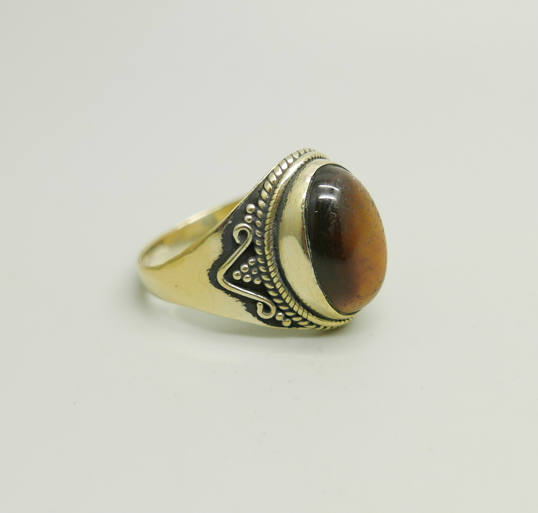 A silver gilt ring set with a cabochon tiger's eye stone, W - Image 2 of 3