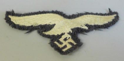 A German Luftwaffe breast eagle cloth wings badge with accompanying black and white identification