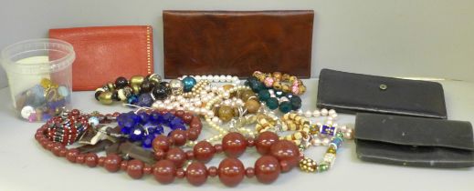 A collection of costume jewellery, a container of glass and other stones and four leather wallets/