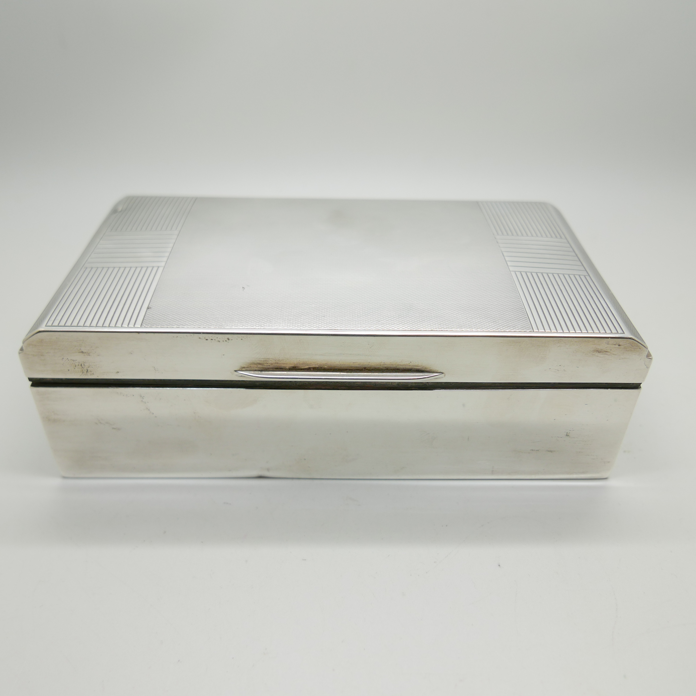 An Art Deco silver cigarette box, Walker & Hall, total weight with liner 654g, 17.5cm wide, dent