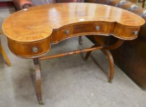 A Regency style inlaid mahogany kidney shaped three drawer writing table