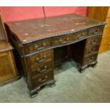 An Edward VII Chippendale style mahogany and leather topped serpentine desk