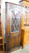 A carved oak linenfold free standing corner cabinet
