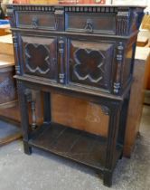 An early 20th Century Jacobean Revival oak cupboard on stand