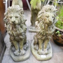 A pair of concrete garden figures of seated concrete lions