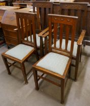 A set of four Arts and Crafts Liberty & Co. style carved oak dining chairs