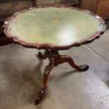 A Regency style mahogany and green leather topped tripod coffee table