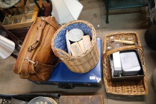 A briefcase, leather work satchel and baskets with assorted picnic ware