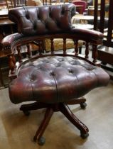 A mahogany and burgundy leather revolving captain's desk chair