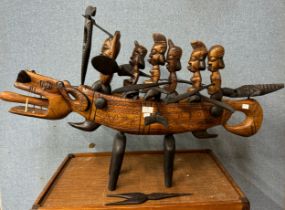 An African Gambian carved wood dragon canoe, with bone teeth
