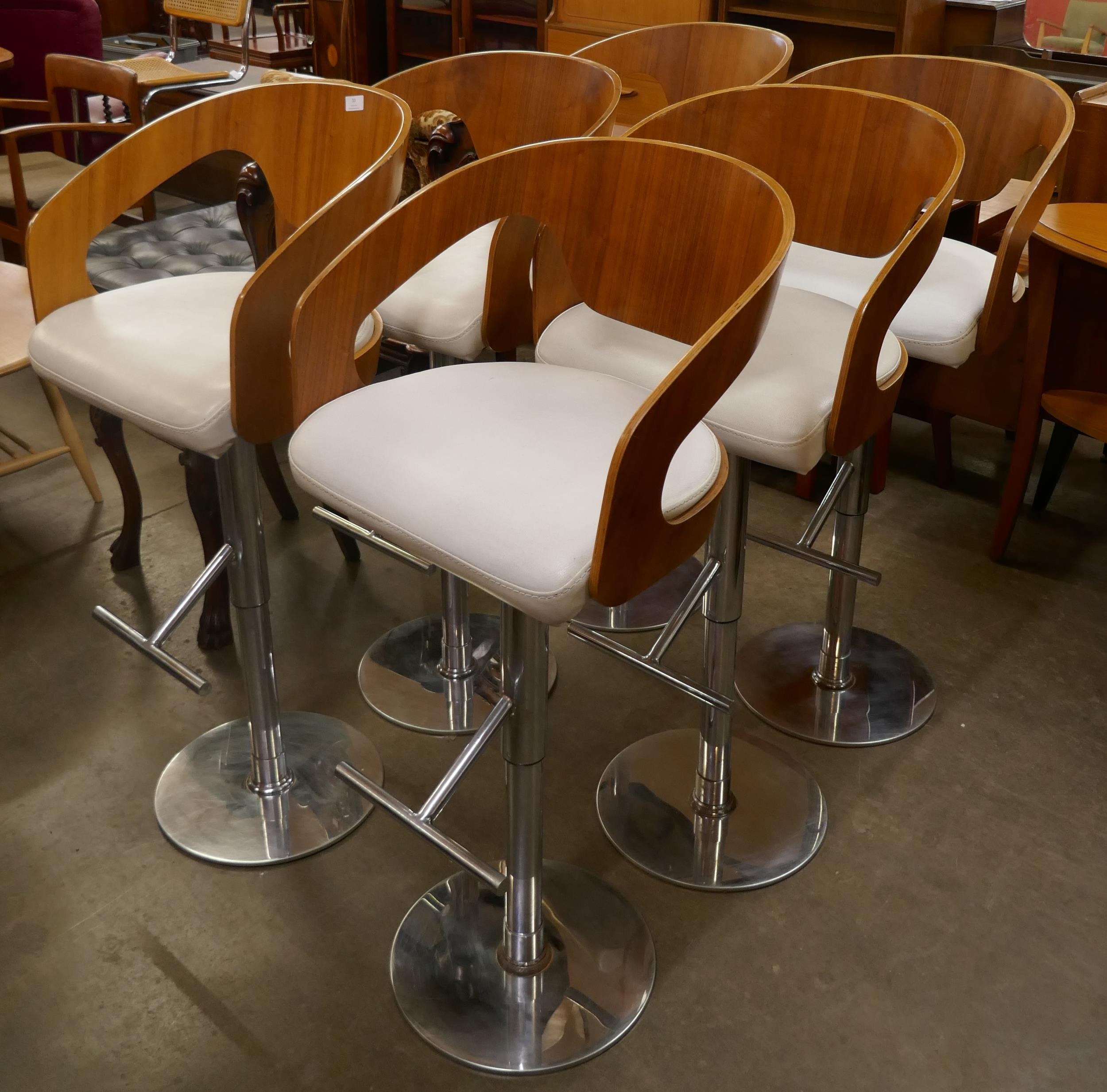 A set of six teak and chrome revolving bar stools
