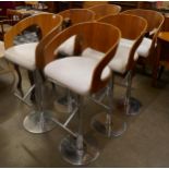 A set of six teak and chrome revolving bar stools