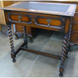 An early 20th Century geometric moulded oak and leather toppwd two drawer barleytwist writing table