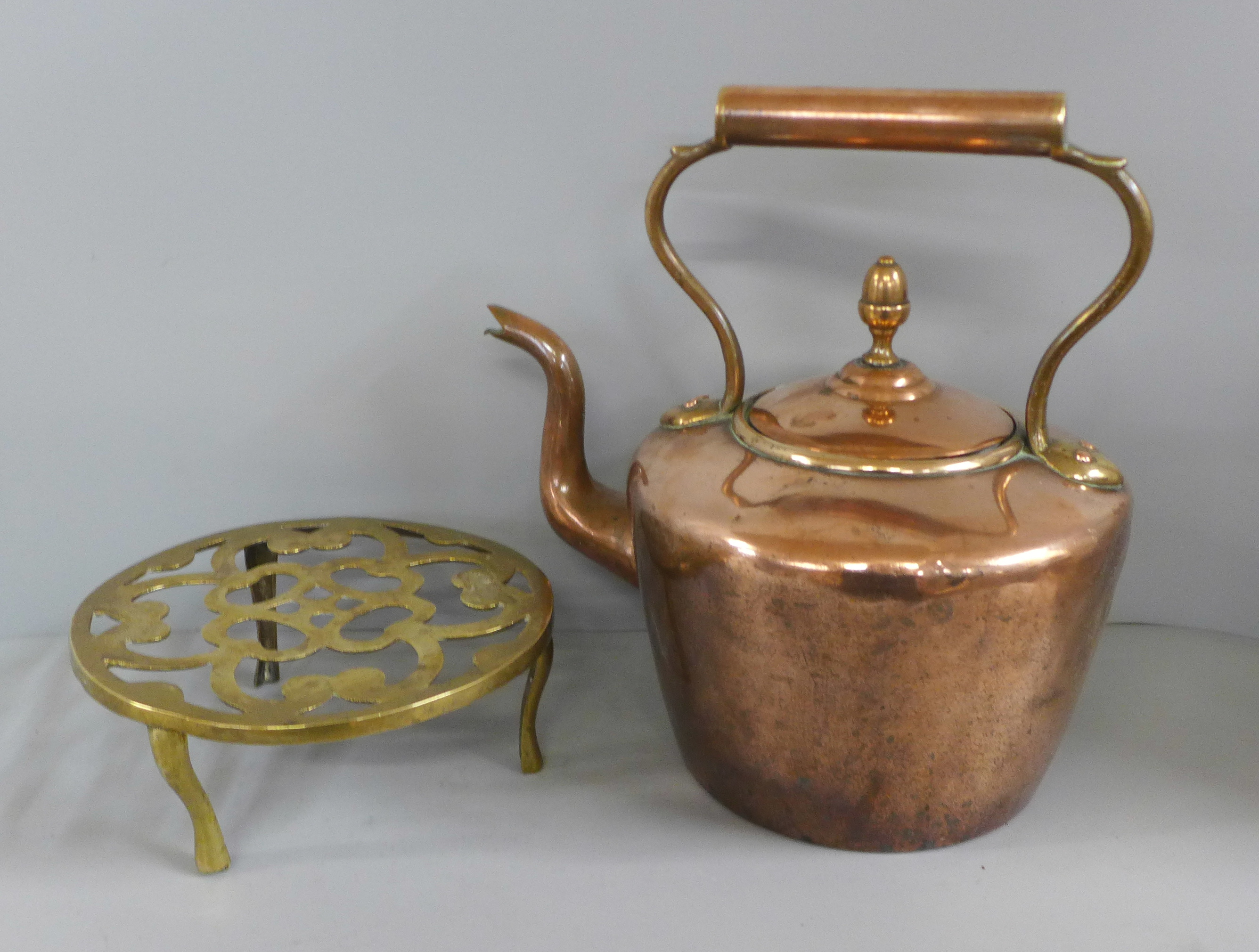 A Victorian copper kettle and a brass trivet