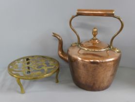 A Victorian copper kettle and a brass trivet
