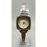 A lady's silver wristwatch with hammered design bezel and strap, hallmarked on the clasp with