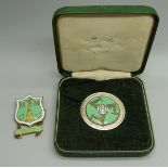 A Manx Grand Prix medallion for completion of the course, cased, together with a badge for