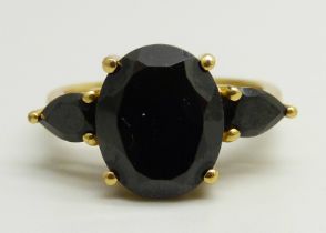 A silver gilt ring set with three black stones, O