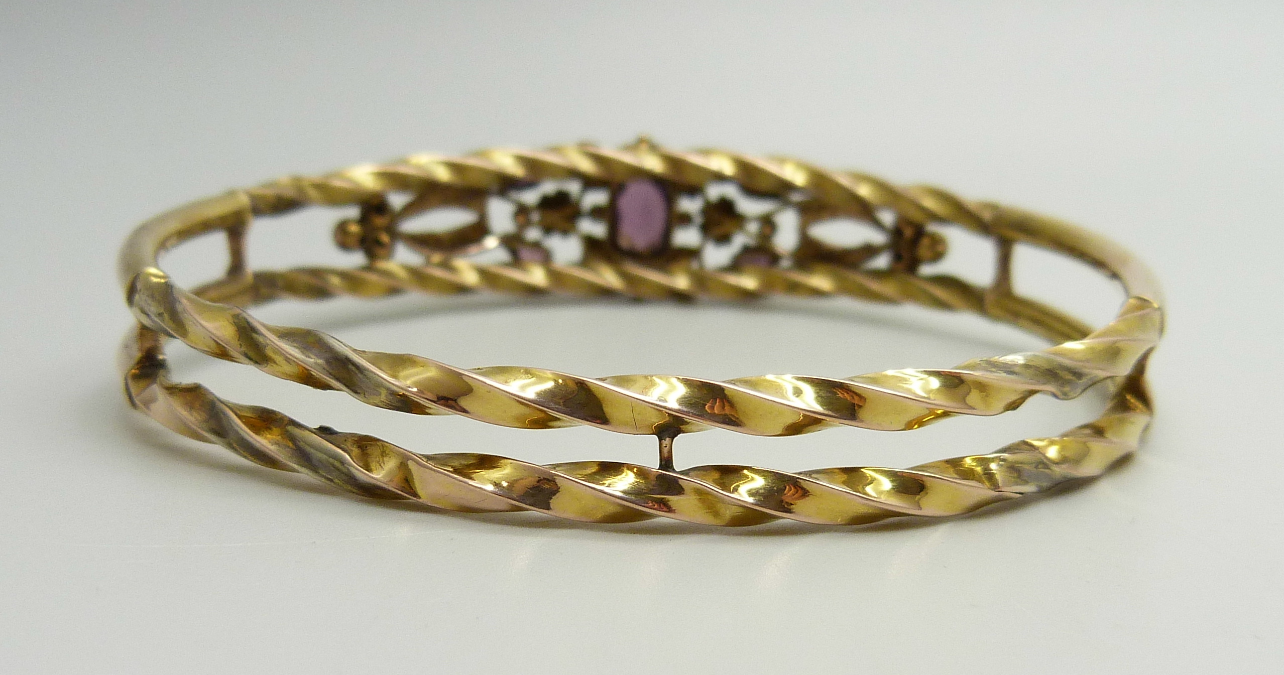 A yellow metal bangle set with purple stones and seed pearls, a/f (one pearl missing, one stone - Image 4 of 4