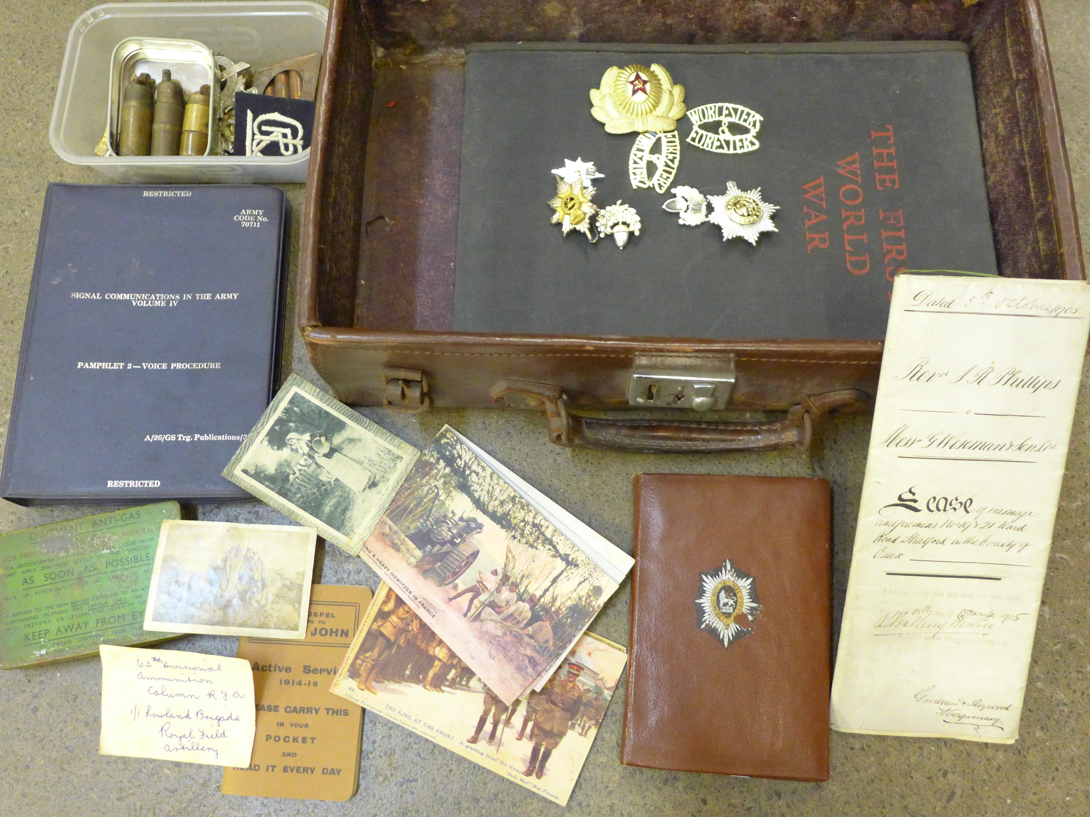 A suitcase containing military items from WWI onwards, assorted cap badges including Glasgow