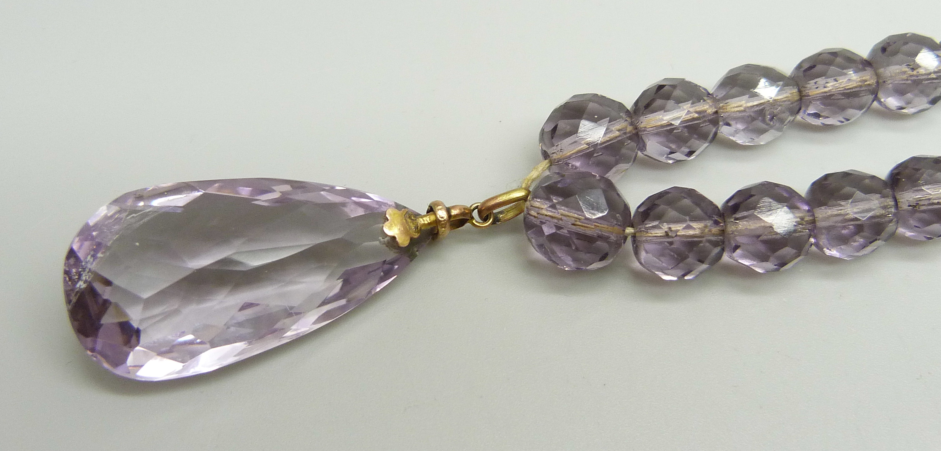 A faceted amethyst bead necklace, the bale marked 9ct, with a base metal clasp, 4.6cm pendant - Image 2 of 3