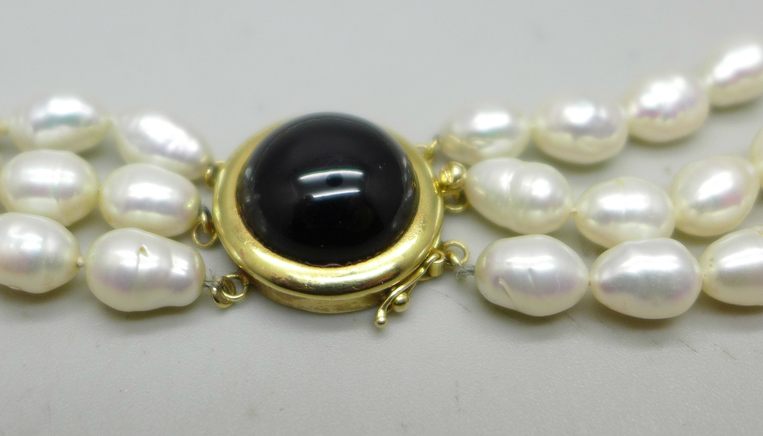 A three strand freshwater pearl necklace with a gold clasp marked 14K 585, 75g - Image 2 of 3