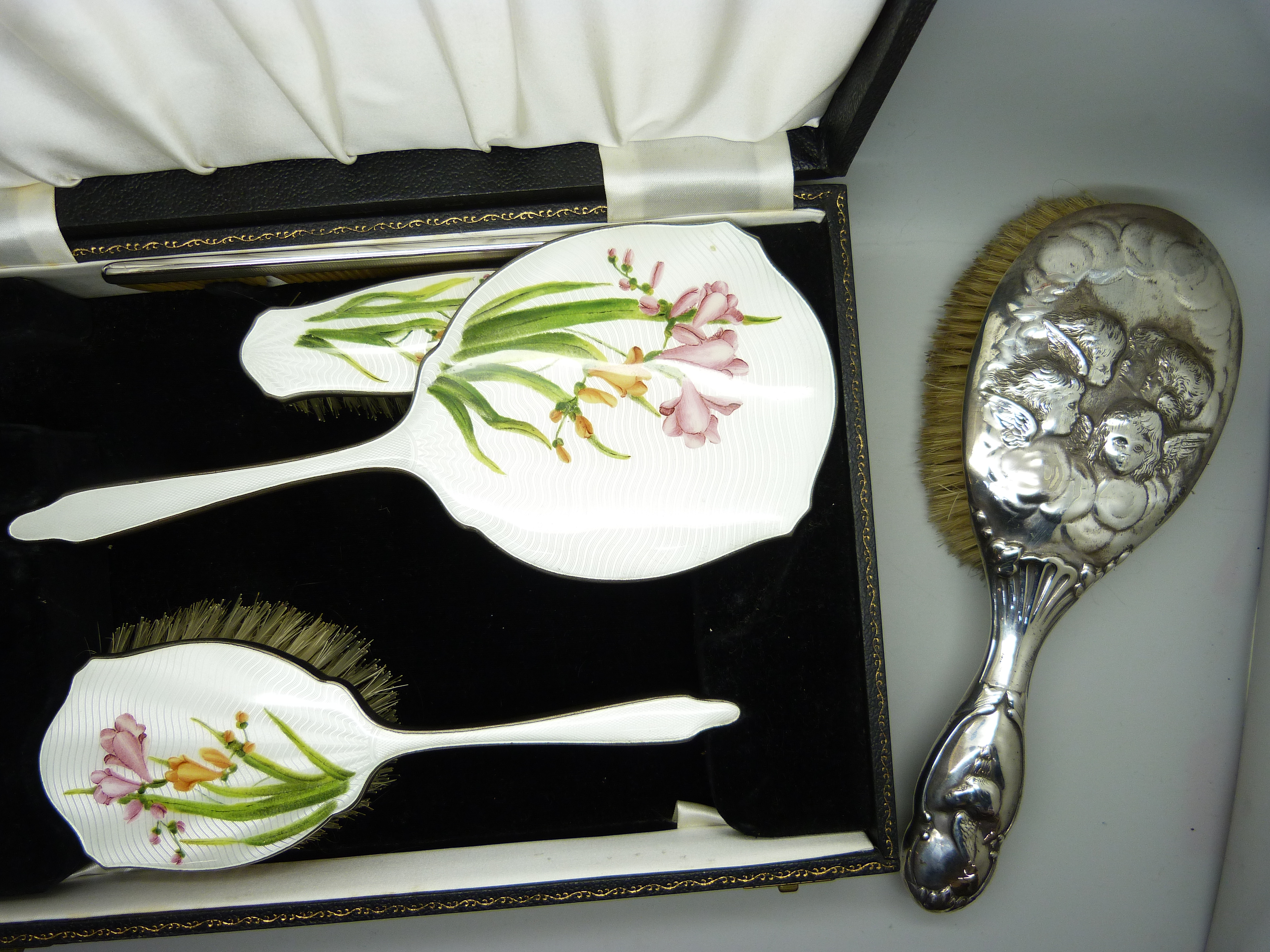 A cased silver plated dressing table set with floral design, cased, together with a silver