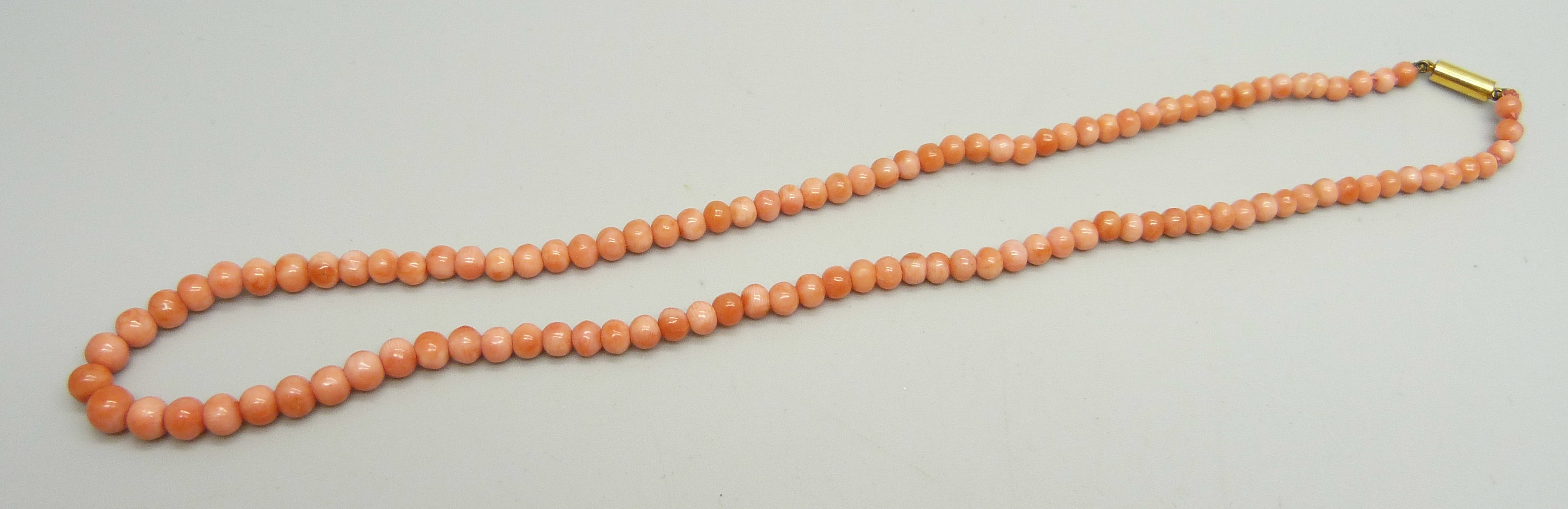 A graduated coral necklace, the clasp marked 9ct, 39.5cm, 10.3g