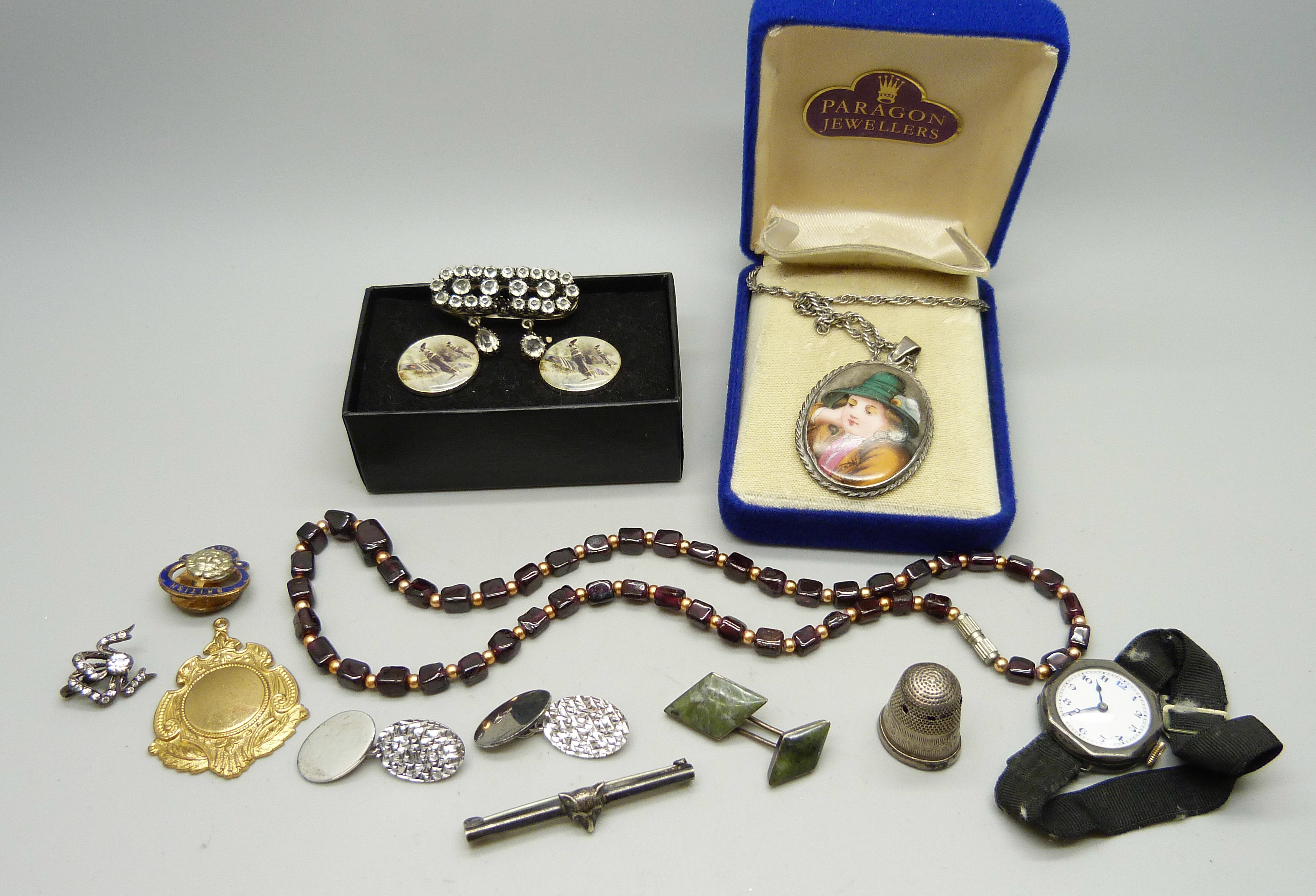 A garnet necklace, a pair of silver cufflinks, a silver cased wristwatch, a silver fox bar brooch,