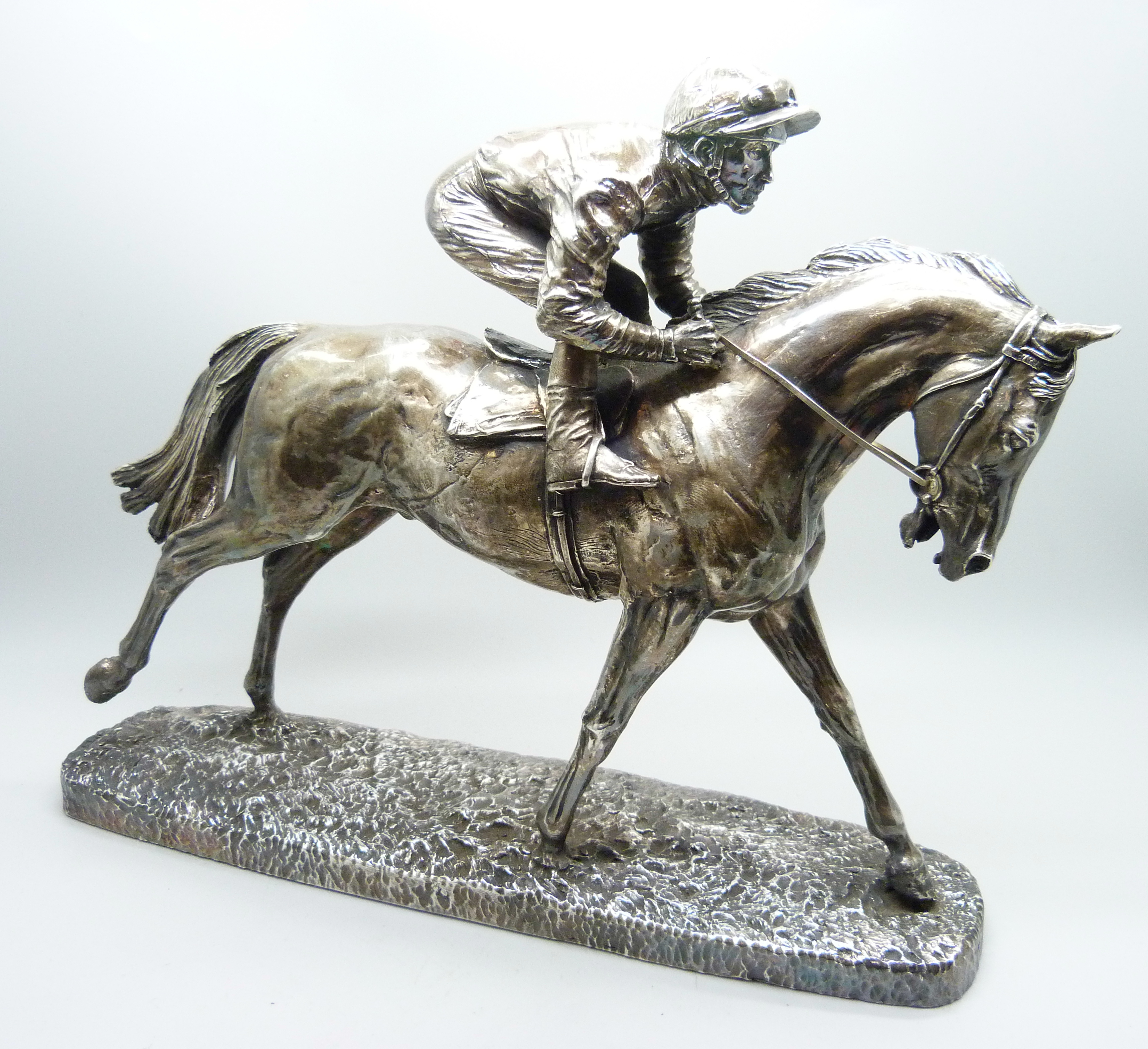 A hallmarked silver model of a racehorse and jockey, resin filled, Sheffield 1997, base 26.5cm x 6.