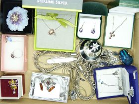 A collection of silver jewellery including three silver pendants on chains, two pairs of earrings, a