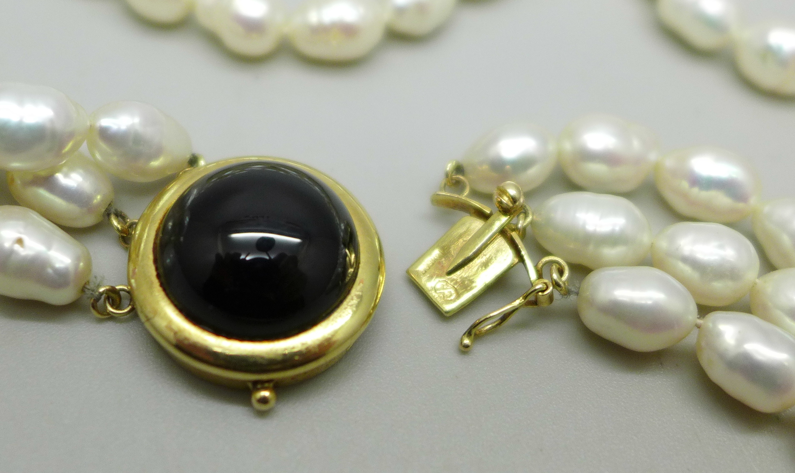 A three strand freshwater pearl necklace with a gold clasp marked 14K 585, 75g - Image 3 of 3