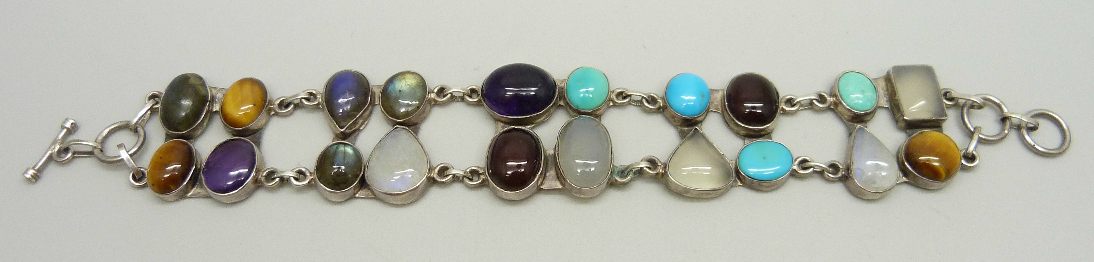 A silver bracelet set with twenty gemstones including tiger's eye, amethyst, moonstone,