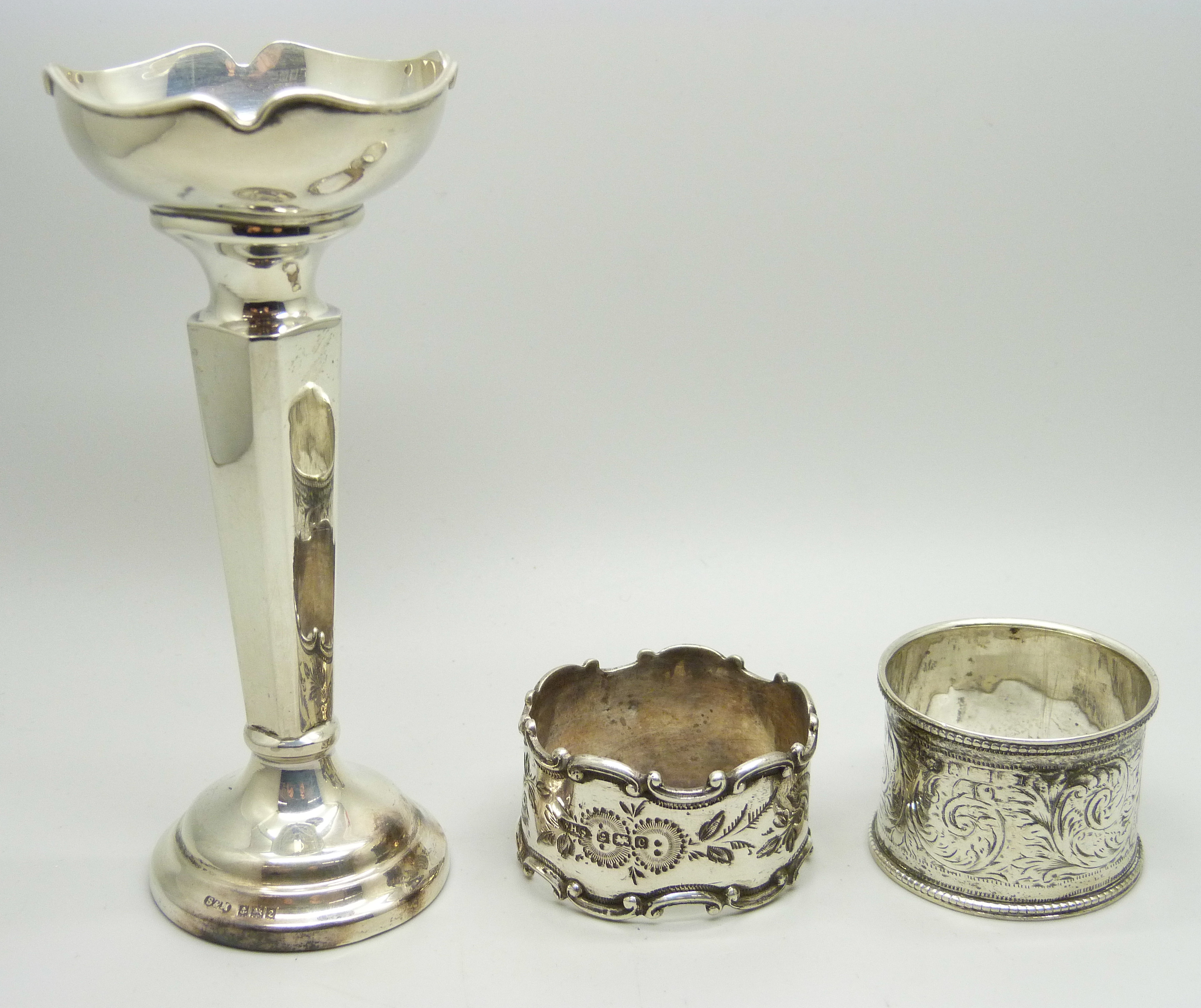 A silver posy vase, 12.5cm and two silver napkin rings, (vase with weighted base), total weight