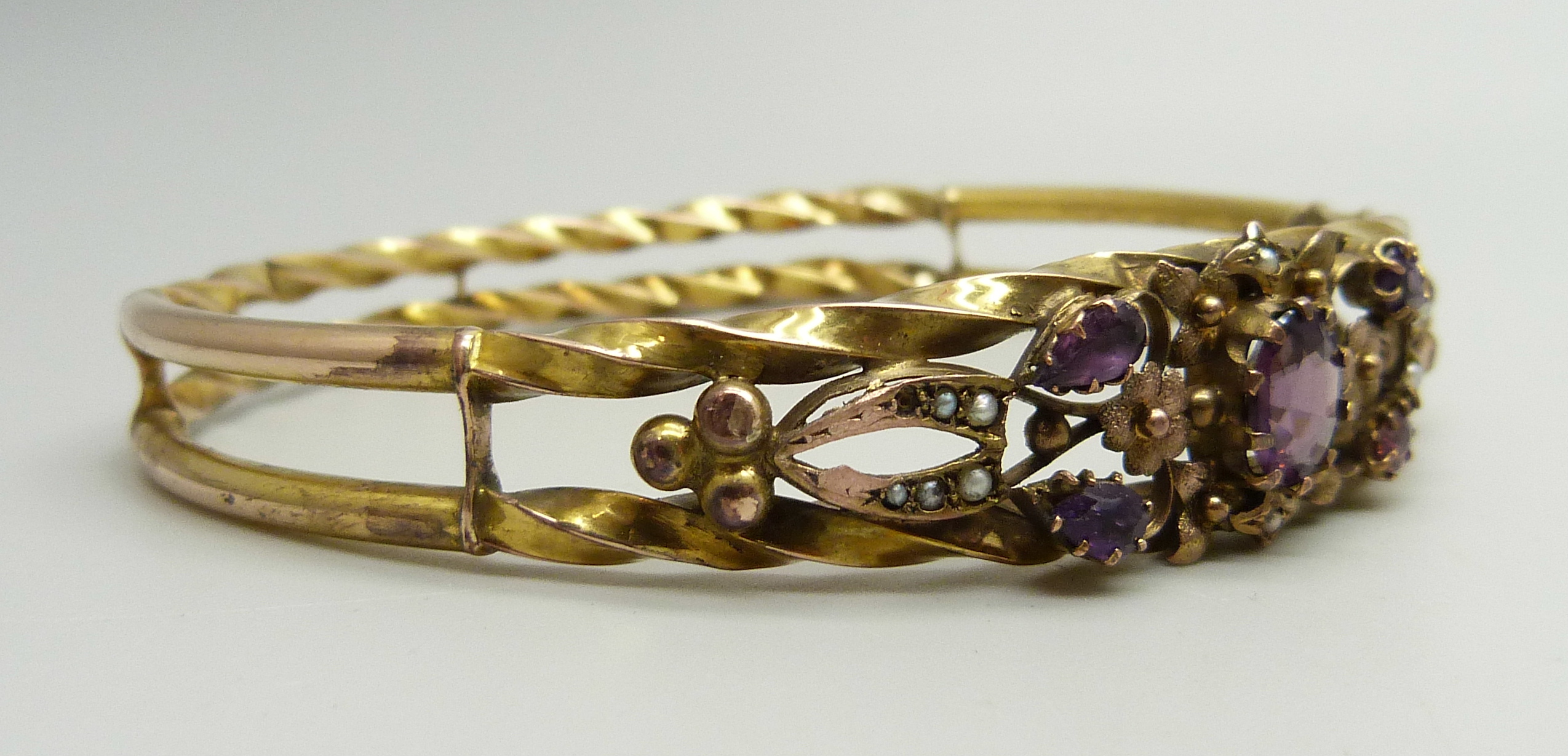 A yellow metal bangle set with purple stones and seed pearls, a/f (one pearl missing, one stone - Image 3 of 4