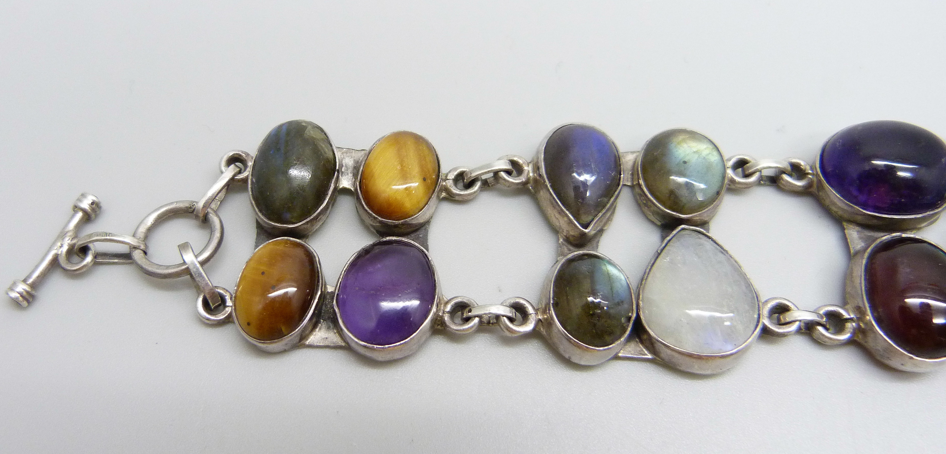 A silver bracelet set with twenty gemstones including tiger's eye, amethyst, moonstone, - Image 2 of 4