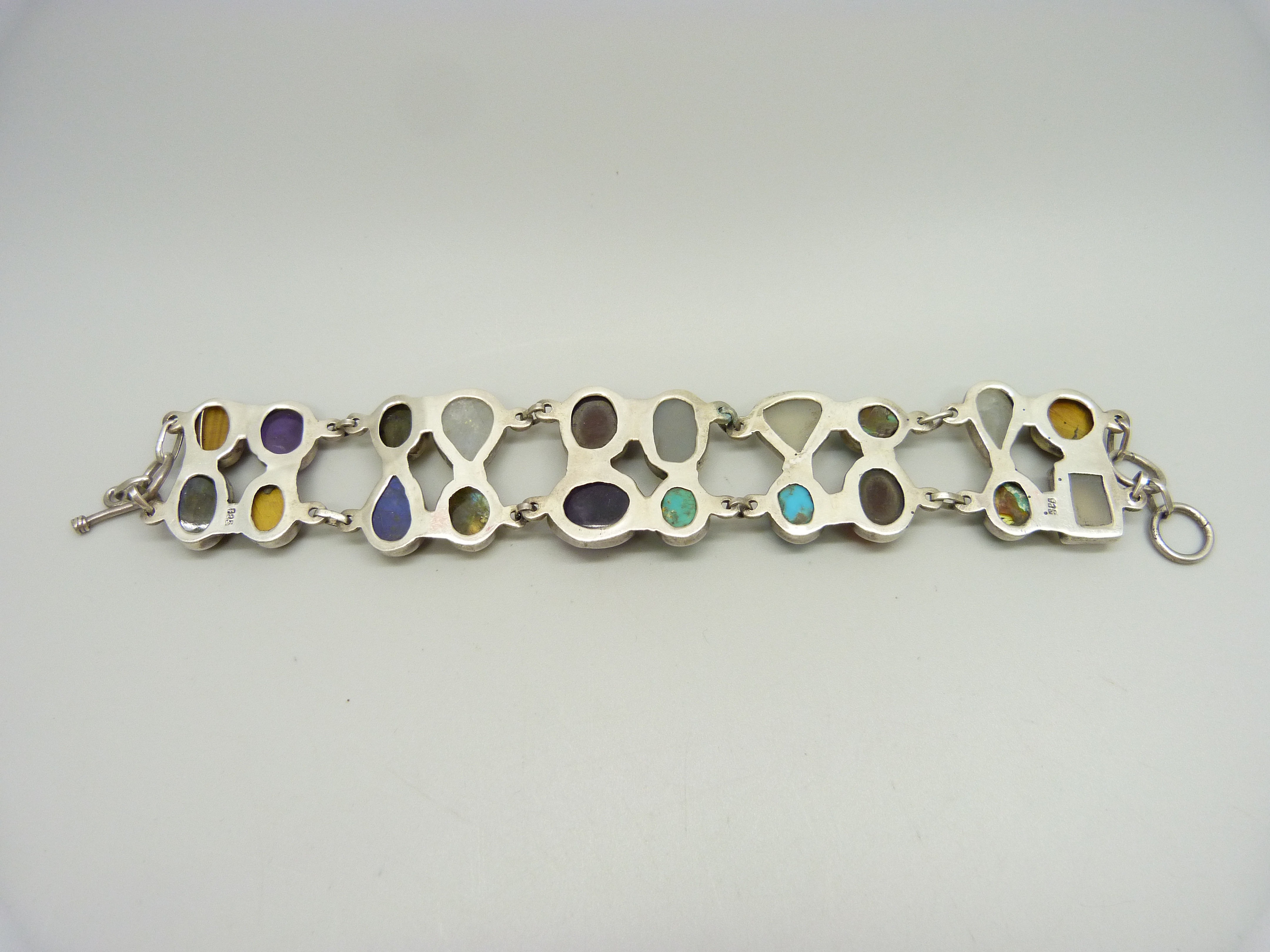 A silver bracelet set with twenty gemstones including tiger's eye, amethyst, moonstone, - Image 4 of 4