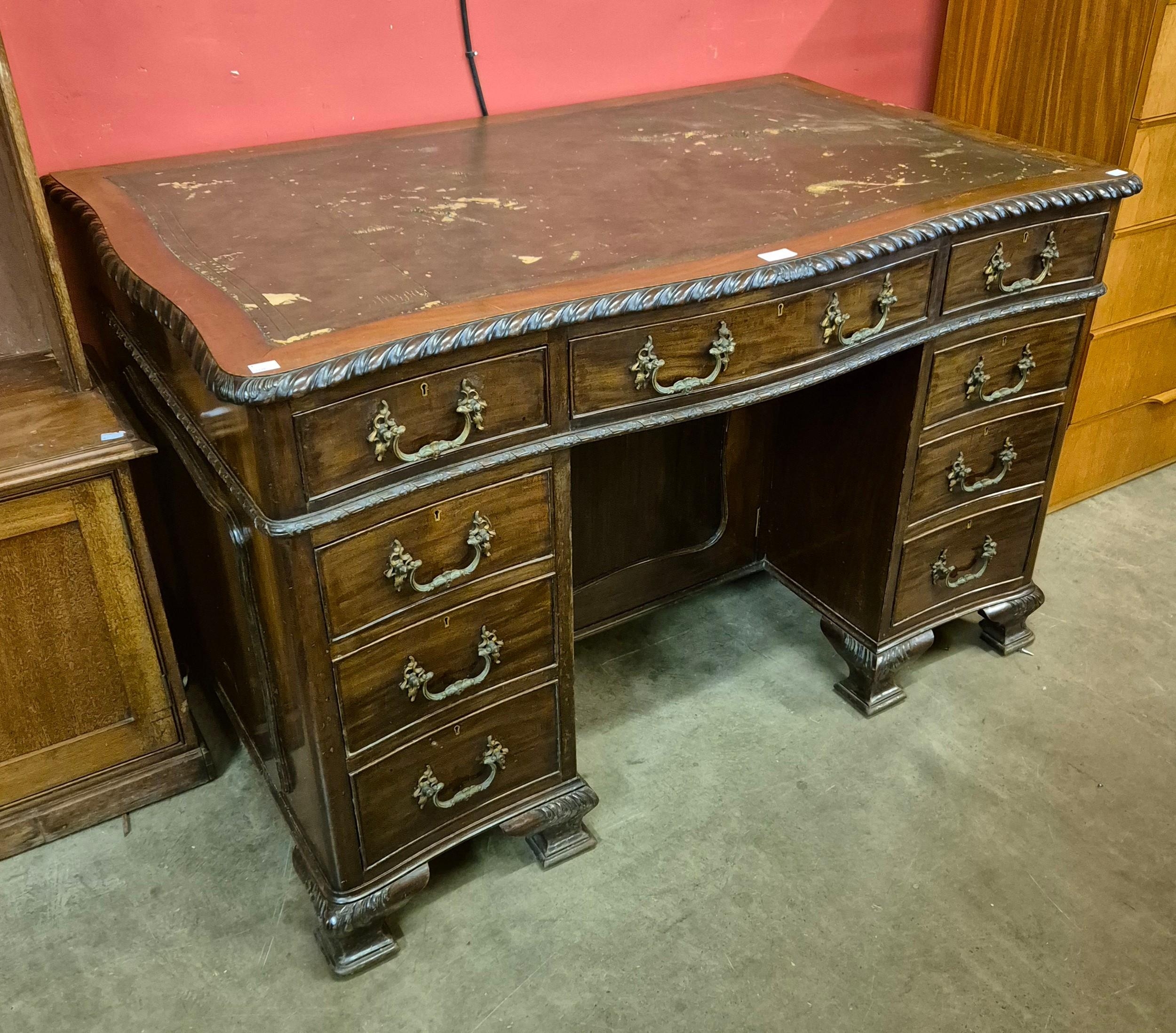 An Edward VII Chippendale style mahogany and leather topped serpentine desk