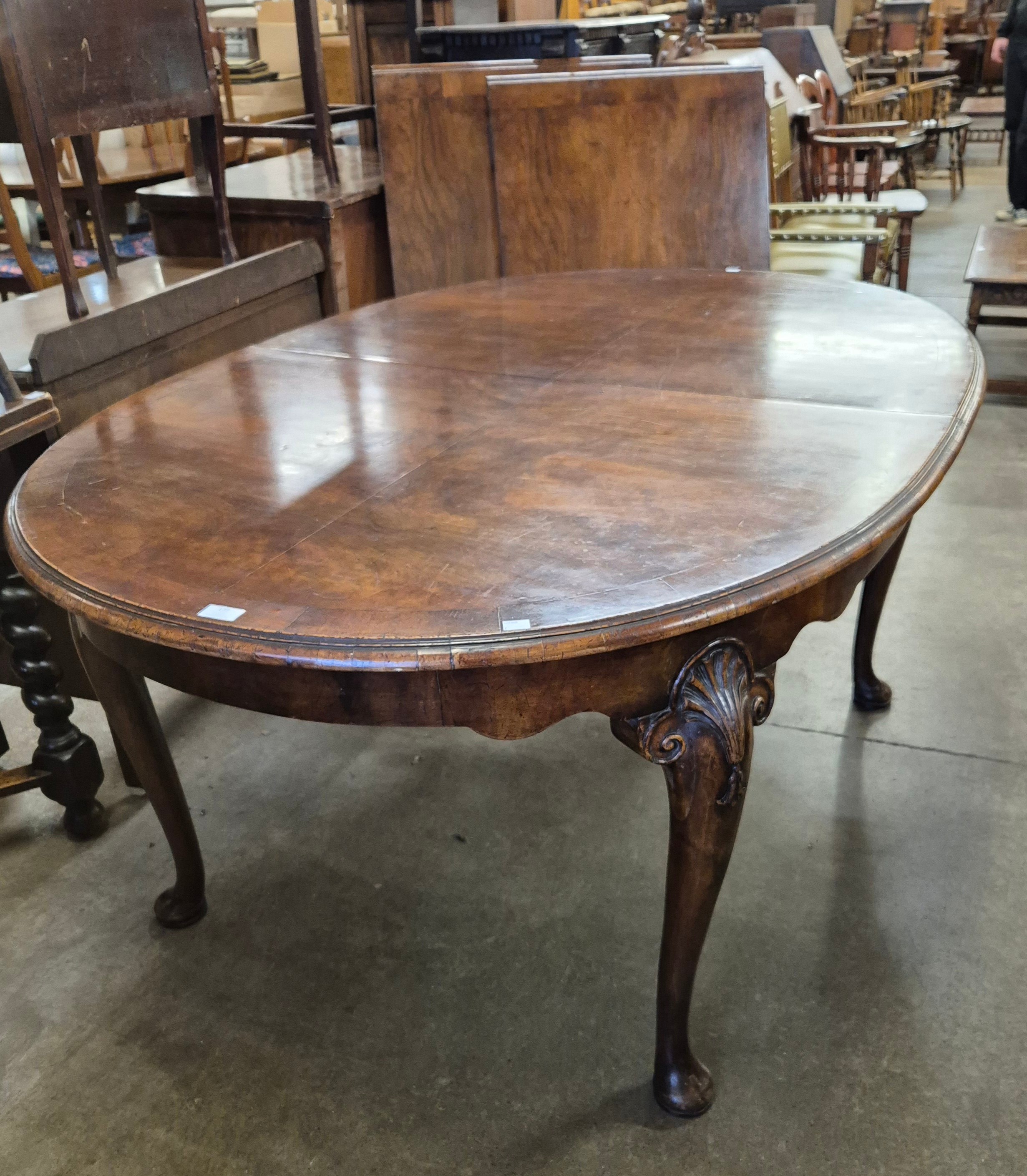 A Queen Anne style walnut oval extending dining table