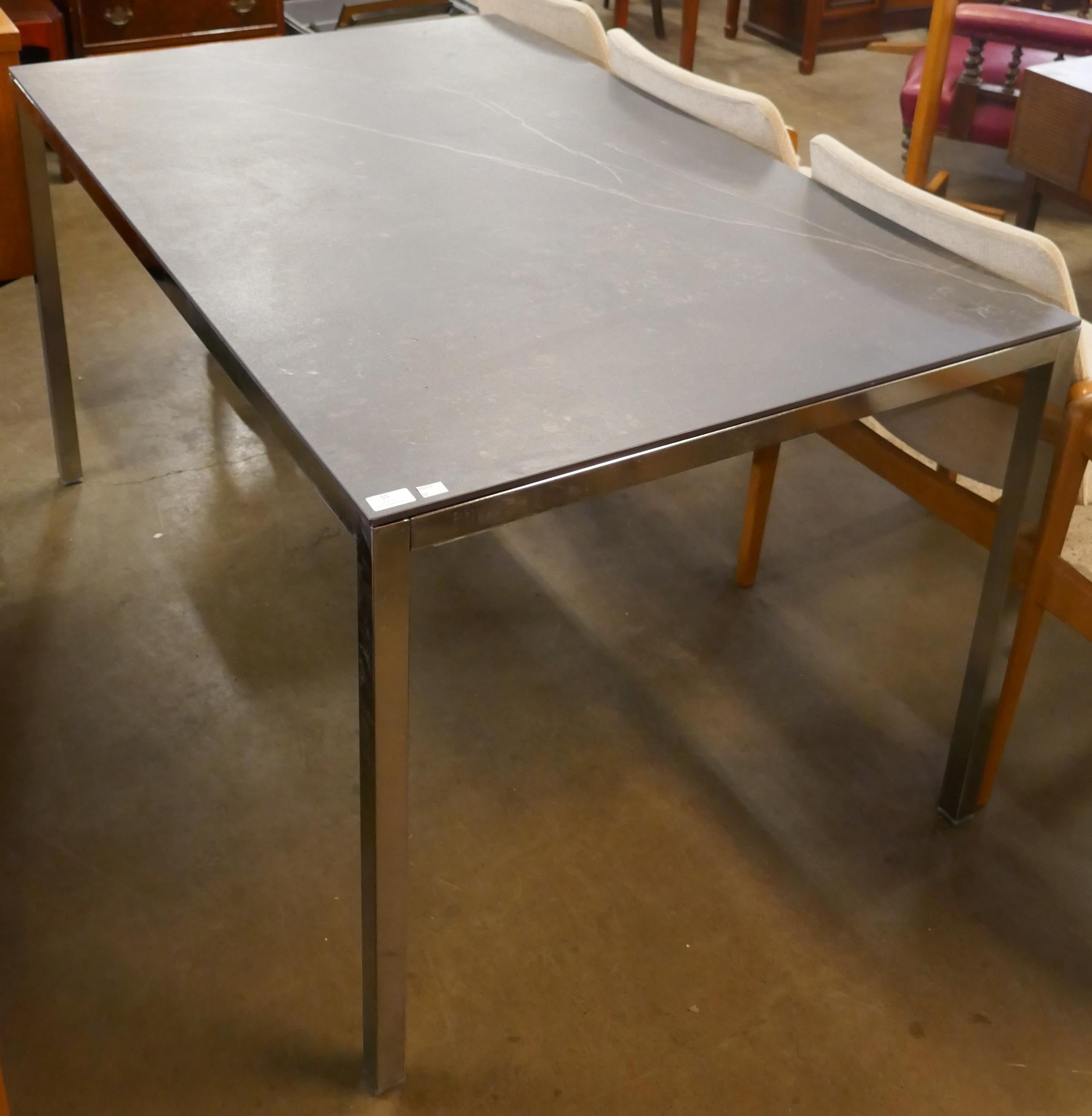 A chrome and slate topped rectangular dining table