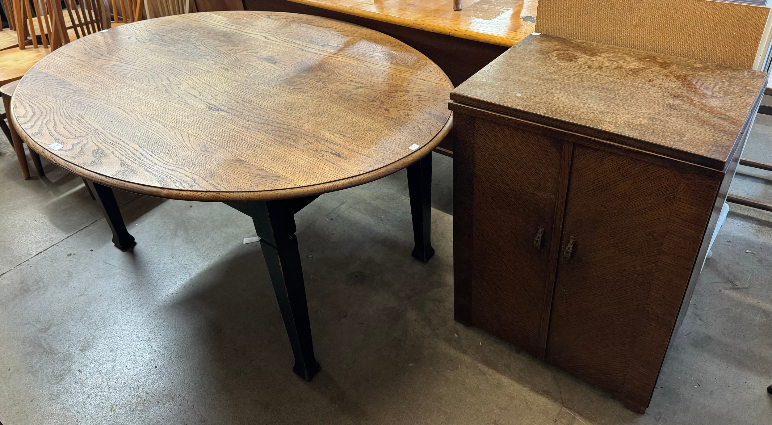 An oak sewing cupboard and oak oval dining table