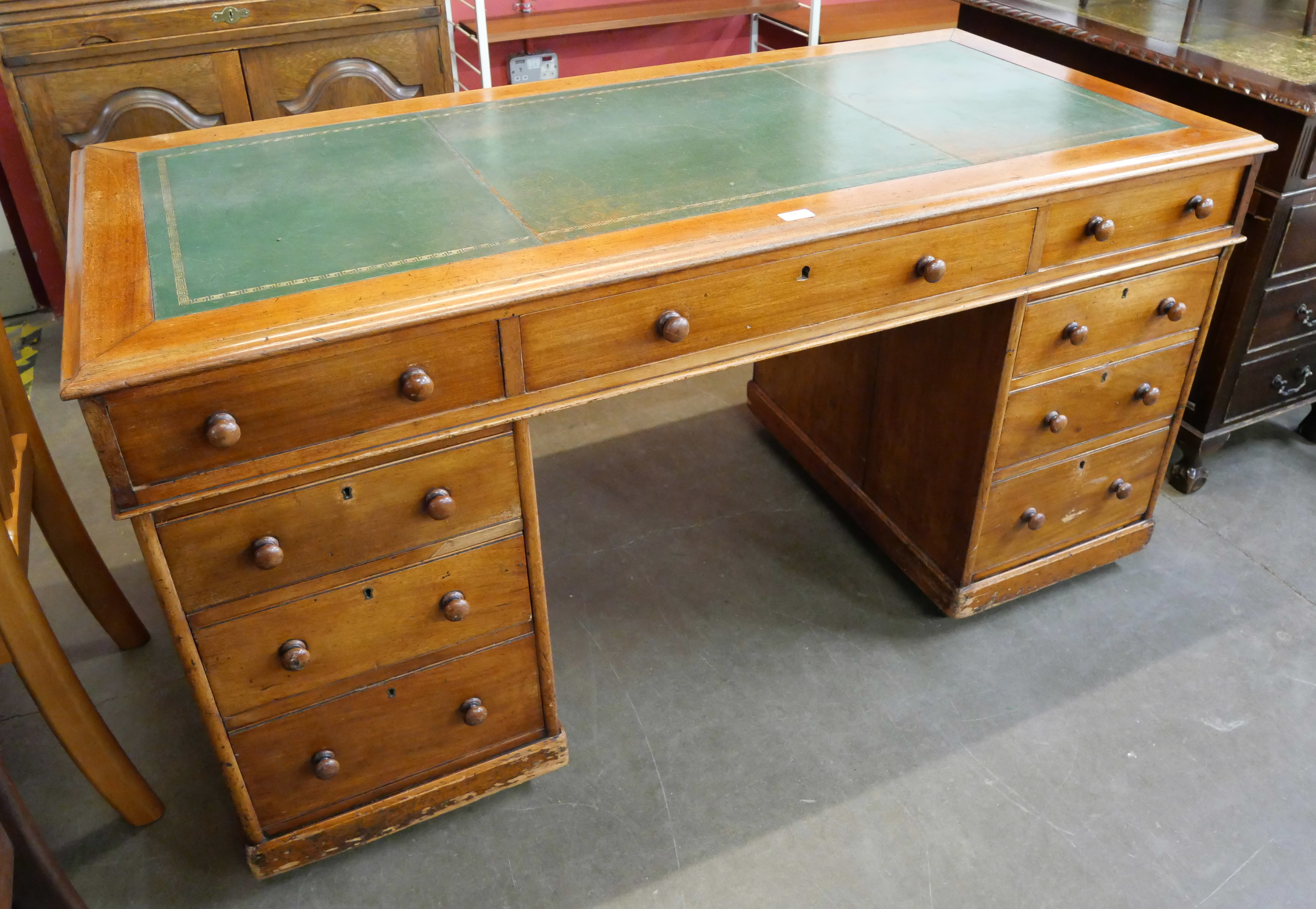 A Victorian mahogany and green leather topped pedestal desk