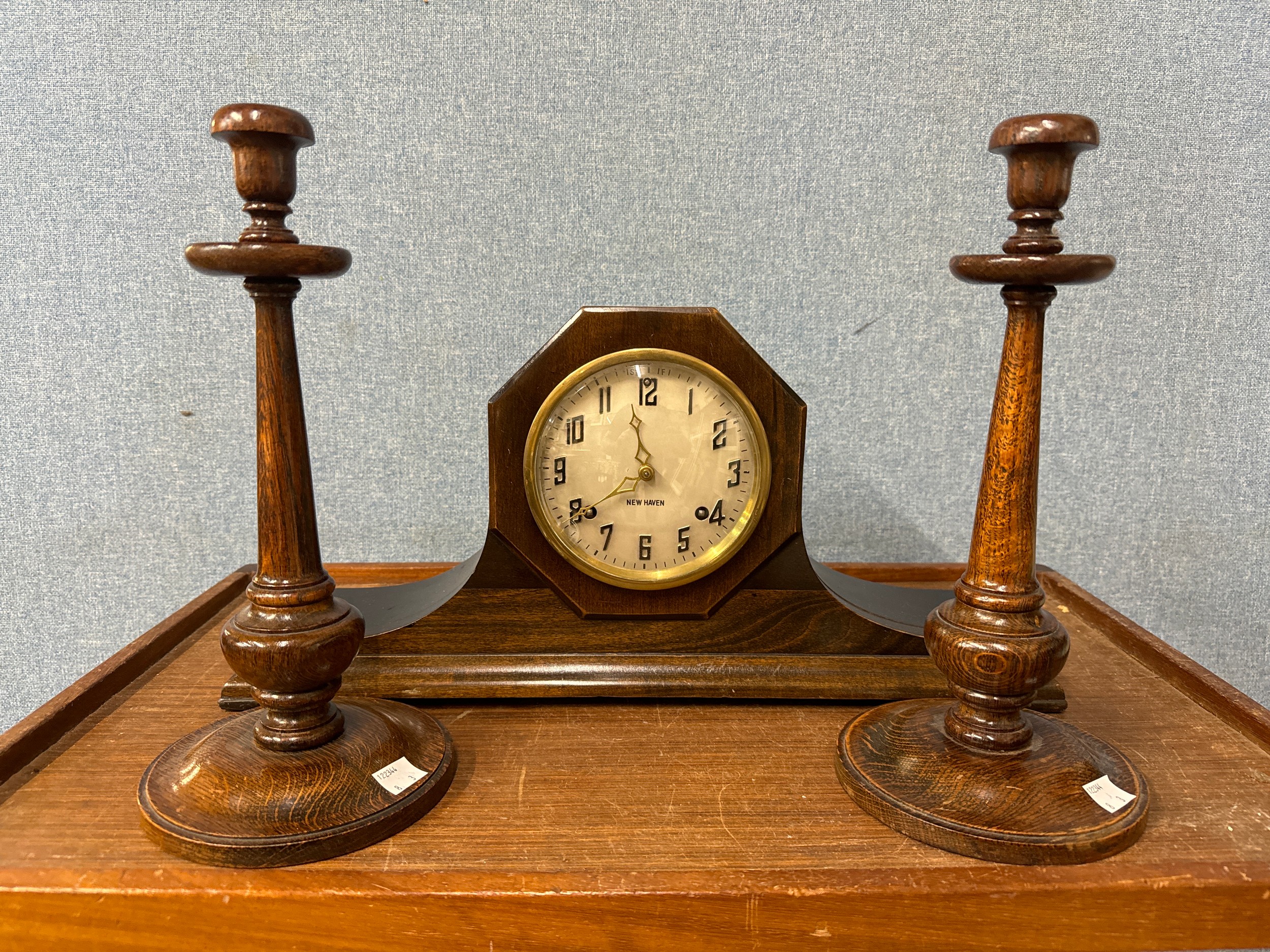 A pair of oak candlesticks and a mantel clock