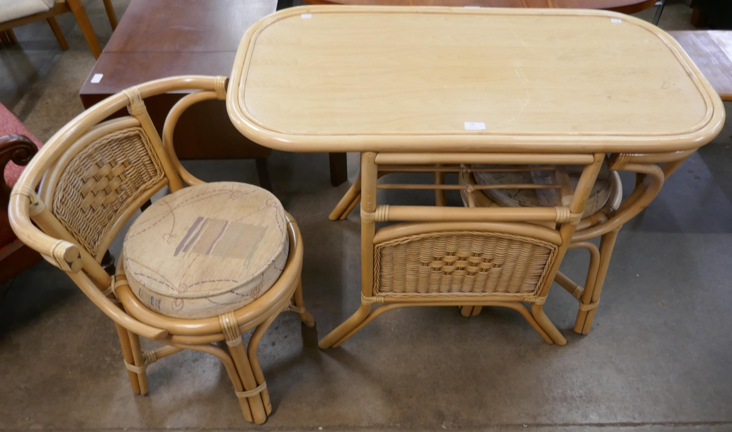 A wicker and rattan table and two chairs
