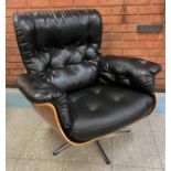 An Eames style simulated rosewood and black vinyl revolving armchair, on chrome base