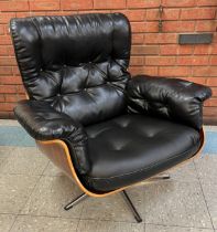 An Eames style simulated rosewood and black vinyl revolving armchair, on chrome base