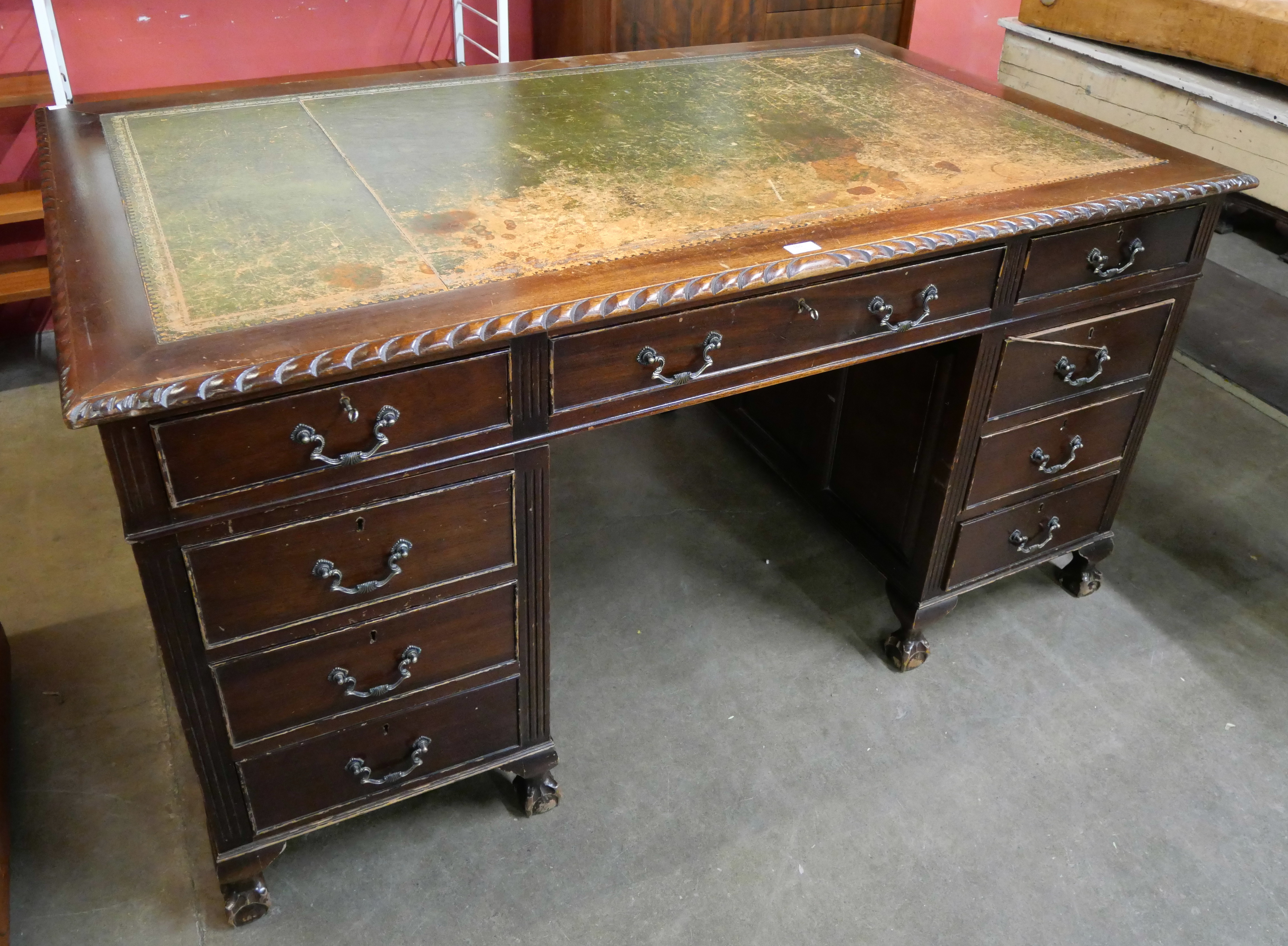 A George III style mahogany and green leather topped pedestal desk